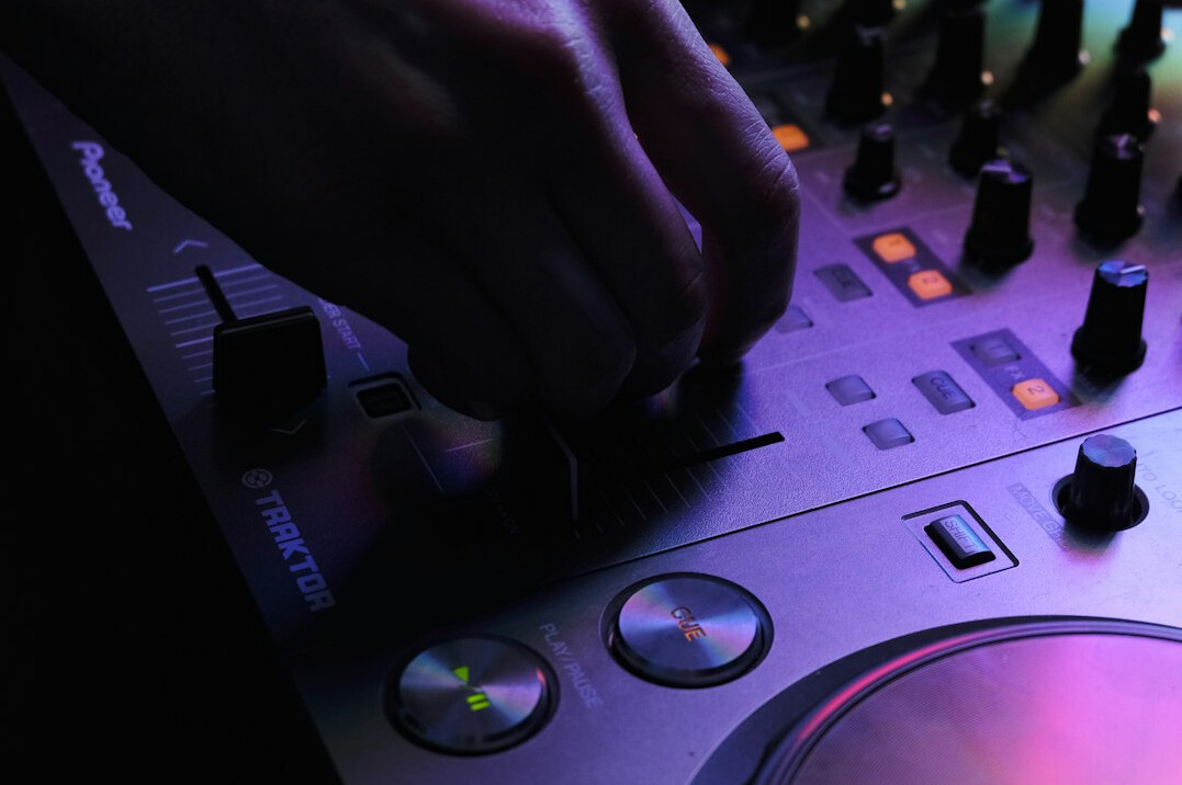 Hands on a vision mixer pressing cut and mix buttons during a live show