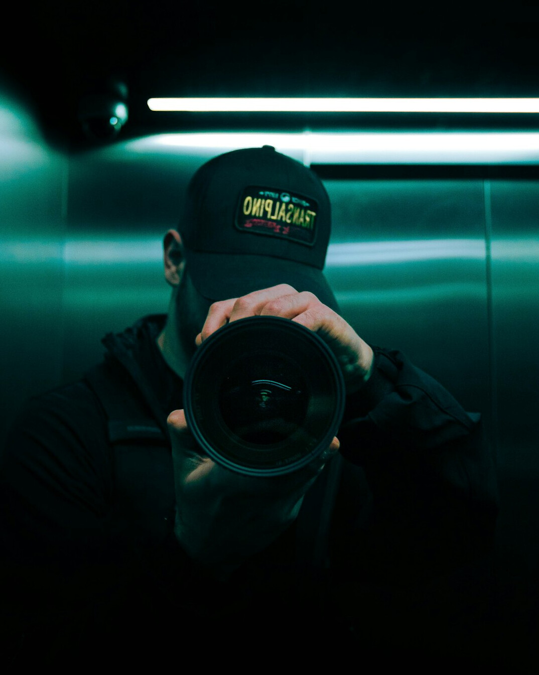 Camera operator filming with a shoulder broadcast camera in a studio
